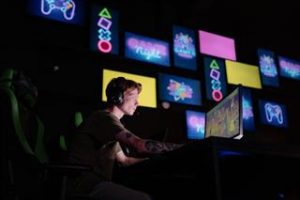 Tips voor aanschaffen van een gaming pc: persoon werkt aan computersetup met gaming equipment