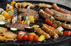 Man grillt vlees op kolen bbq in de achtertuin bij een bbq bij jou thuis